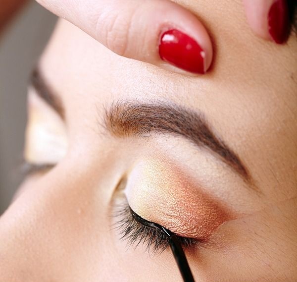 Closeup portrait of a beautiful woman having makeup applied